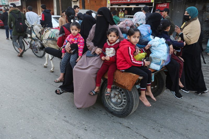 Pengungsi Palestina berjalan di jalan saat mereka kembali ke rumah mereka, selama gencatan senjata sementara antara Hamas dan Israel, di Khan Younis di selatan Jalur Gaza, 24 November 2023. Pengungsi Palestina berjalan di jalan saat mereka kembali ke rumah mereka, selama gencatan senjata sementara antara Hamas dan Israel, di Khan Younis di selatan Jalur Gaza, 24 November 2023. (REUTERS/Ibraheem Abu Mustafa)
