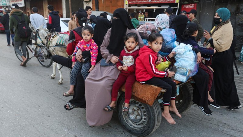 Pengungsi Palestina berjalan di jalan saat mereka kembali ke rumah mereka, selama gencatan senjata sementara antara Hamas dan Israel, di Khan Younis di selatan Jalur Gaza, 24 November 2023. (REUTERS/Ibraheem Abu Mustafa)