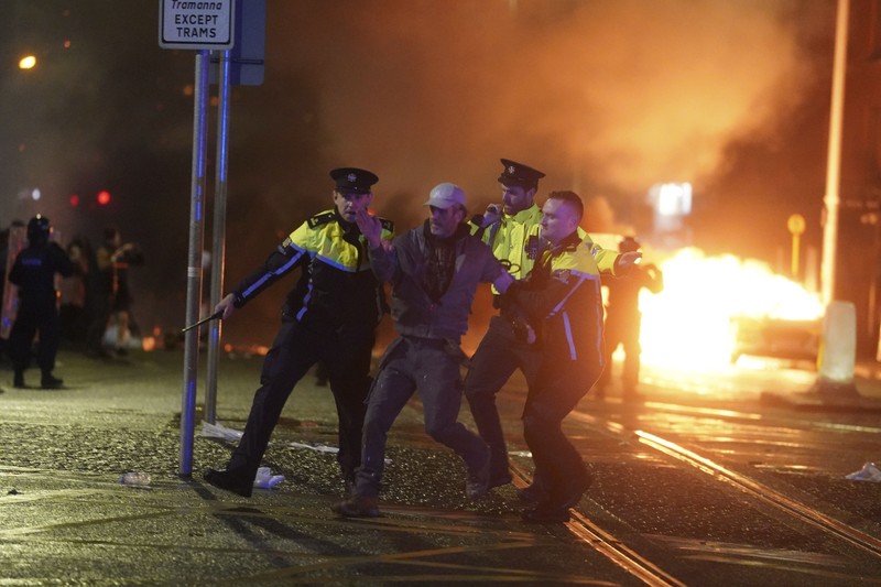 Sebuah bus dan mobil terbakar setelah adegan kekerasan terjadi di pusat kota Dublin, Kamis 23 November 2023 menyusul serangan pisau. Seorang gadis berusia 5 tahun menerima perawatan medis darurat di rumah sakit Dublin menyusul serangan pada hari Kamis yang melibatkan pisau. Seorang wanita dan dua anak lainnya terluka. Polisi Irlandia mengatakan mereka tidak menganggap kasus ini terkait dengan teror, dan bahwa seorang pria berusia 50-an, yang juga dirawat di rumah sakit karena luka serius, adalah “orang yang berkepentingan.” (Brian Lawless/PA via AP)