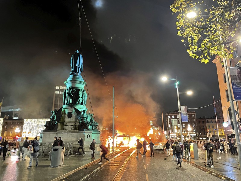 Sebuah bus dan mobil terbakar setelah adegan kekerasan terjadi di pusat kota Dublin, Kamis 23 November 2023 menyusul serangan pisau. Seorang gadis berusia 5 tahun menerima perawatan medis darurat di rumah sakit Dublin menyusul serangan pada hari Kamis yang melibatkan pisau. Seorang wanita dan dua anak lainnya terluka. Polisi Irlandia mengatakan mereka tidak menganggap kasus ini terkait dengan teror, dan bahwa seorang pria berusia 50-an, yang juga dirawat di rumah sakit karena luka serius, adalah “orang yang berkepentingan.” (Brian Lawless/PA via AP)