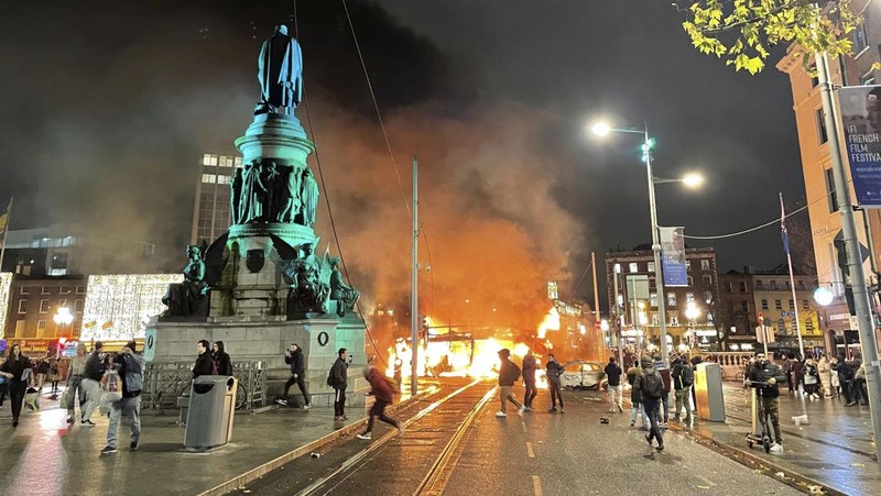 Sebuah bus dan mobil terbakar setelah adegan kekerasan terjadi di pusat kota Dublin, Kamis 23 November 2023 menyusul serangan pisau. Seorang gadis berusia 5 tahun menerima perawatan medis darurat di rumah sakit Dublin menyusul serangan pada hari Kamis yang melibatkan pisau. Seorang wanita dan dua anak lainnya terluka. Polisi Irlandia mengatakan mereka tidak menganggap kasus ini terkait dengan teror, dan bahwa seorang pria berusia 50-an, yang juga dirawat di rumah sakit karena luka serius, adalah “orang yang berkepentingan.” (Brian Lawless/PA via AP)