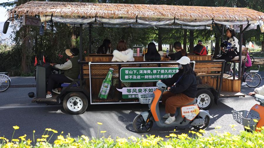 Seorang pria bernyanyi untuk menghibur pelanggan yang sedang berkeliling danau Erhai dengan bus wisata, di Dali, provinsi Yunnan, Tiongkok 10 November 2023. (REUTERS/Florence Lo)