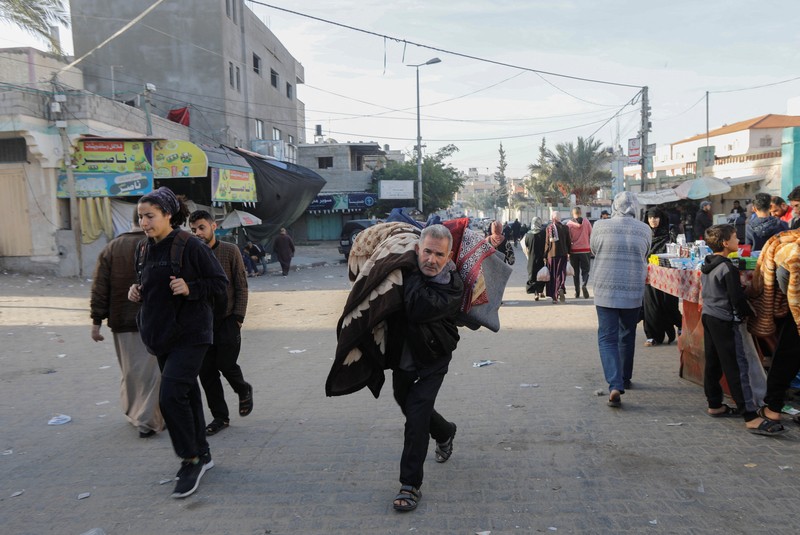 Pengungsi Palestina berjalan di jalan saat mereka kembali ke rumah mereka, selama gencatan senjata sementara antara Hamas dan Israel, di Khan Younis di selatan Jalur Gaza, 24 November 2023. Pengungsi Palestina berjalan di jalan saat mereka kembali ke rumah mereka, selama gencatan senjata sementara antara Hamas dan Israel, di Khan Younis di selatan Jalur Gaza, 24 November 2023. (REUTERS/Ibraheem Abu Mustafa)