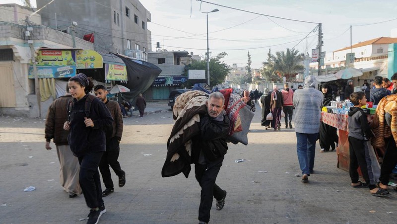 Pengungsi Palestina berjalan di jalan saat mereka kembali ke rumah mereka, selama gencatan senjata sementara antara Hamas dan Israel, di Khan Younis di selatan Jalur Gaza, 24 November 2023. (REUTERS/Ibraheem Abu Mustafa)
