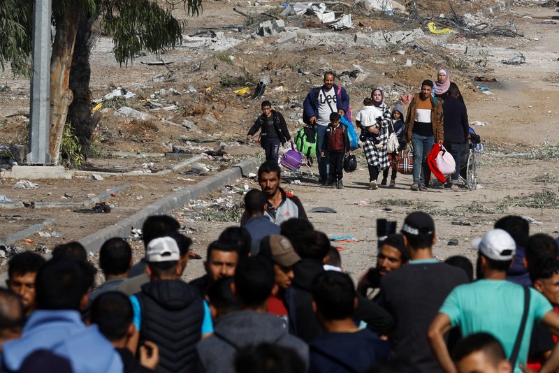 Pengungsi Palestina berjalan di jalan saat mereka kembali ke rumah mereka, selama gencatan senjata sementara antara Hamas dan Israel, di Khan Younis di selatan Jalur Gaza, 24 November 2023. (REUTERS/Ibraheem Abu Mustafa)