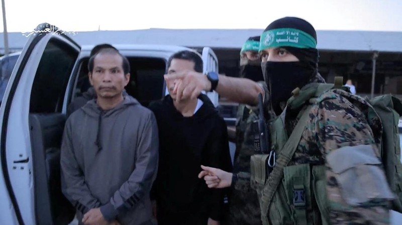Para sandera yang diculik oleh orang-orang bersenjata Hamas selama serangan 7 Oktober terhadap Israel diserahkan oleh militan Hamas ke Palang Merah Internasional, sebagai bagian dari kesepakatan pertukaran sandera-tahanan antara Hamas dan Israel di tengah gencatan senjata sementara, di lokasi yang tidak diketahui di Israel. Jalur Gaza, 24 November 2023. (Hamas Military Wing/Handout via REUTERS)