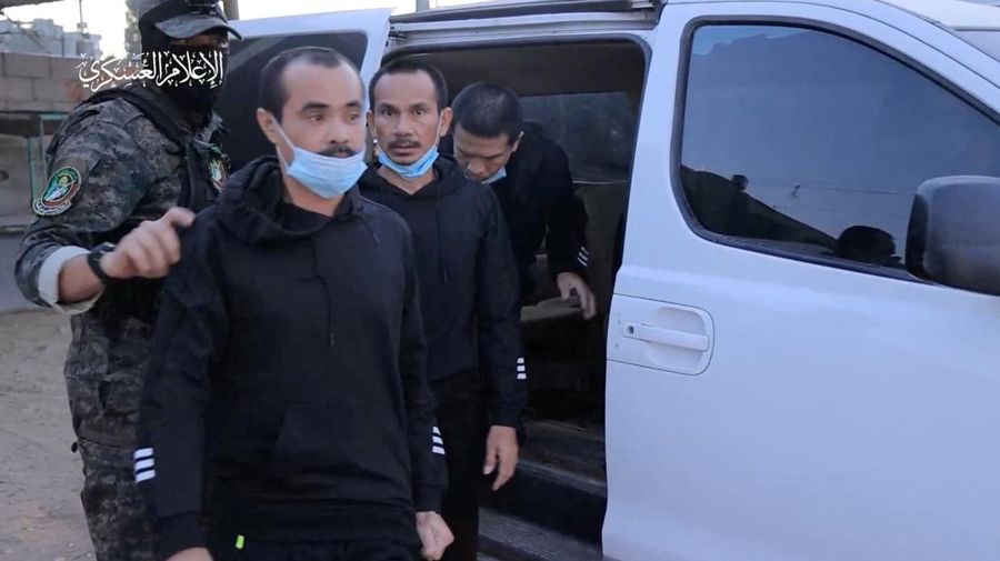Para sandera yang diculik oleh orang-orang bersenjata Hamas selama serangan 7 Oktober terhadap Israel diserahkan oleh militan Hamas ke Palang Merah Internasional, sebagai bagian dari kesepakatan pertukaran sandera-tahanan antara Hamas dan Israel di tengah gencatan senjata sementara, di lokasi yang tidak diketahui di Israel. Jalur Gaza, 24 November 2023. (Hamas Military Wing/Handout via REUTERS)
