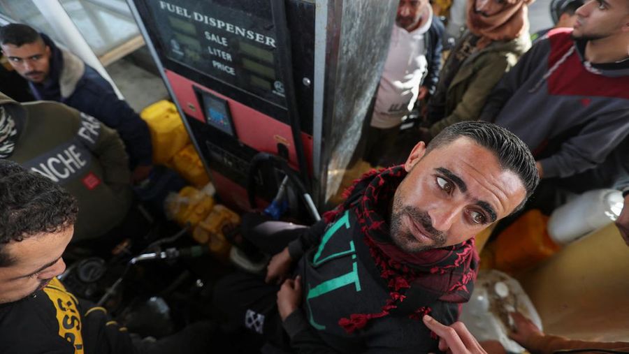 Truk bantuan bergerak di jalan ketika warga Palestina menyaksikan, selama gencatan senjata sementara antara Hamas dan Israel, di Rafah, di selatan Jalur Gaza 25 November 2023. (REUTERS/Ibraheem Abu Mustafa)