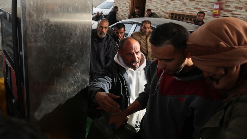 Truk bantuan bergerak di jalan ketika warga Palestina menyaksikan, selama gencatan senjata sementara antara Hamas dan Israel, di Rafah, di selatan Jalur Gaza 25 November 2023. (REUTERS/Ibraheem Abu Mustafa)