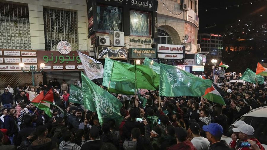 Warga Palestina mengibarkan bendera Hamas saat merayakan pembebasan tahanan Palestina oleh Israel di kota Nablus, Tepi Barat, Jumat, 24 November 2023. Pembebasan tersebut terjadi pada hari pertama dari kesepakatan gencatan senjata empat hari antara Israel dan Hamas selama dimana militan Gaza telah berjanji untuk melepaskan 50 sandera dengan imbalan 150 warga Palestina yang dipenjarakan oleh Israel. (AP Photo/Majdi Mohammed)