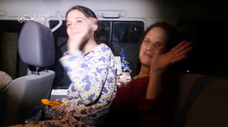 Hostages who were abducted by Hamas gunmen during the October 7 attack on Israel, are handed over by Hamas militants to members of the International Committee of the Red Cross, as part of a hostages-prisoners swap deal between Hamas and Israel amid a temporary truce, in an unknown location in the Gaza Strip, in this screengrab taken from video released November 26, 2023. Hamas Military Wing/Handout via REUTERS THIS IMAGE HAS BEEN SUPPLIED BY A THIRD PARTY