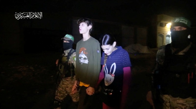 Hostages who were abducted by Hamas gunmen during the October 7 attack on Israel, are handed over by Hamas militants to members of the International Committee of the Red Cross, as part of a hostages-prisoners swap deal between Hamas and Israel amid a temporary truce, in an unknown location in the Gaza Strip, in this screengrab taken from video released November 26, 2023. Hamas Military Wing/Handout via REUTERS THIS IMAGE HAS BEEN SUPPLIED BY A THIRD PARTY