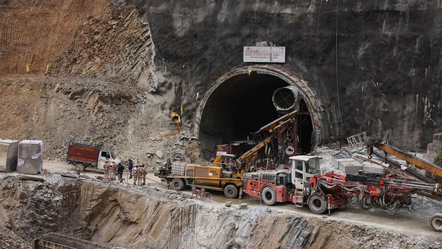 Personel media dan penonton berkumpul di dekat pintu masuk terowongan yang sedang dibangun tempat para pekerja terjebak setelah runtuhnya terowongan, di Uttarkashi, di negara bagian utara Uttarakhand, India, 24 November 2023. (REUTERS/Stringer)
