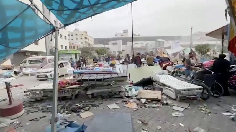 Warga Palestina memeriksa Rumah Sakit Al Shifa yang digerebek oleh pasukan Israel selama operasi darat, di tengah gencatan senjata sementara antara Israel dan kelompok Islam Palestina Hamas, di Kota Gaza, 25 November 2023. (REUTERS/Abed Sabah)