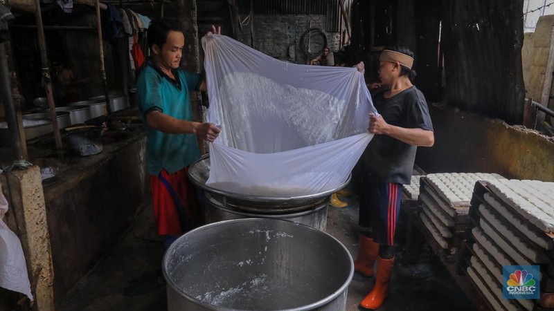 Pekerja menggiling kedelai pada salah satu pabrik tahu di Jakarta, Senin (27/11/2023). Pabrik tahu milik Haji Imroni tetap melakukan produksi seperti biasa meski harga kacang kedelai di pasaran telah menembus Rp 17.300/Kg dari yang sebelumnya Rp 13.000/Kg. (CNBC Indonesia/Faisal Rahman)