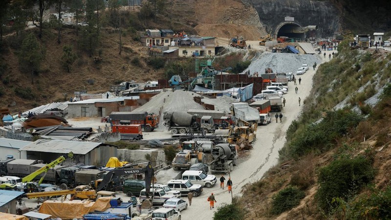 Personel media dan penonton berkumpul di dekat pintu masuk terowongan yang sedang dibangun tempat para pekerja terjebak setelah runtuhnya terowongan, di Uttarkashi, di negara bagian utara Uttarakhand, India, 24 November 2023. (REUTERS/Stringer)