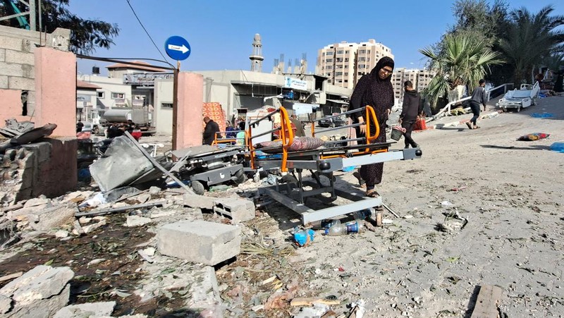 Warga Palestina memeriksa Rumah Sakit Al Shifa yang digerebek oleh pasukan Israel selama operasi darat, di tengah gencatan senjata sementara antara Israel dan kelompok Islam Palestina Hamas, di Kota Gaza, 25 November 2023. (REUTERS/Abed Sabah)