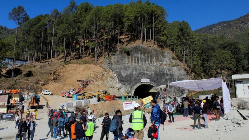 Personel media dan penonton berkumpul di dekat pintu masuk terowongan yang sedang dibangun tempat para pekerja terjebak setelah runtuhnya terowongan, di Uttarkashi, di negara bagian utara Uttarakhand, India, 24 November 2023. (REUTERS/Stringer)