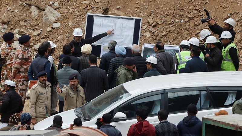 Personel media dan penonton berkumpul di dekat pintu masuk terowongan yang sedang dibangun tempat para pekerja terjebak setelah runtuhnya terowongan, di Uttarkashi, di negara bagian utara Uttarakhand, India, 24 November 2023. (REUTERS/Stringer)