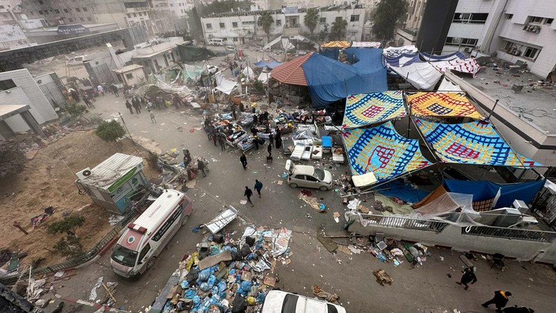 Warga Palestina memeriksa Rumah Sakit Al Shifa yang digerebek oleh pasukan Israel selama operasi darat, di tengah gencatan senjata sementara antara Israel dan kelompok Islam Palestina Hamas, di Kota Gaza, 25 November 2023. (REUTERS/Abed Sabah)