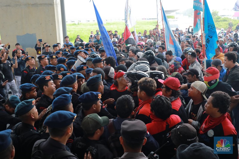 Aliansi buruh Bekasi aksi dorong mendorong dengan petugas kepolisian di Kawasan Industri MM 2100, Kab Bekasi, Jawa Barat, Kamis, (30/11/2023). Buruh yang tergabung dalam Aliansi Buruh Bekasi Melawan (BBM) melakukan aksi unjuk rasa serentak di wilayah kabupaten dan kota Bekasi. (CNBC Indonesia/Muhammad Sabki)