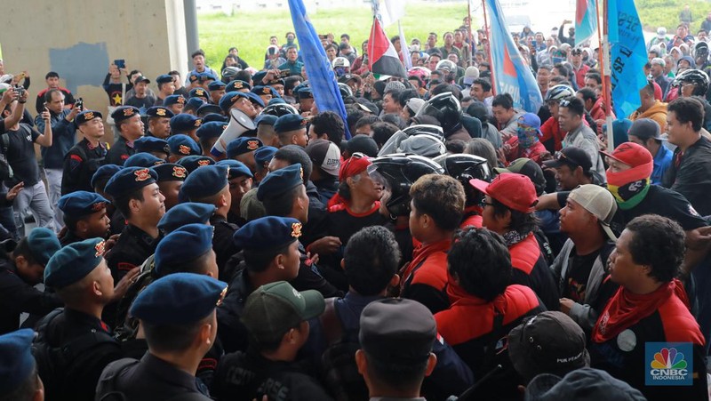 Aliansi buruh Bekasi aksi dorong mendorong dengan petugas kepolisian di Kawasan Industri MM 2100, Kab Bekasi, Jawa Barat, Kamis, (30/11/2023). Buruh yang tergabung dalam Aliansi Buruh Bekasi Melawan (BBM) melakukan aksi unjuk rasa serentak di wilayah kabupaten dan kota Bekasi. (CNBC Indonesia/Muhammad Sabki)