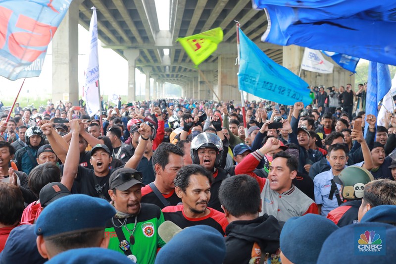 Aliansi buruh Bekasi aksi dorong mendorong dengan petugas kepolisian di Kawasan Industri MM 2100, Kab Bekasi, Jawa Barat, Kamis, (30/11/2023). Buruh yang tergabung dalam Aliansi Buruh Bekasi Melawan (BBM) melakukan aksi unjuk rasa serentak di wilayah kabupaten dan kota Bekasi. (CNBC Indonesia/Muhammad Sabki)