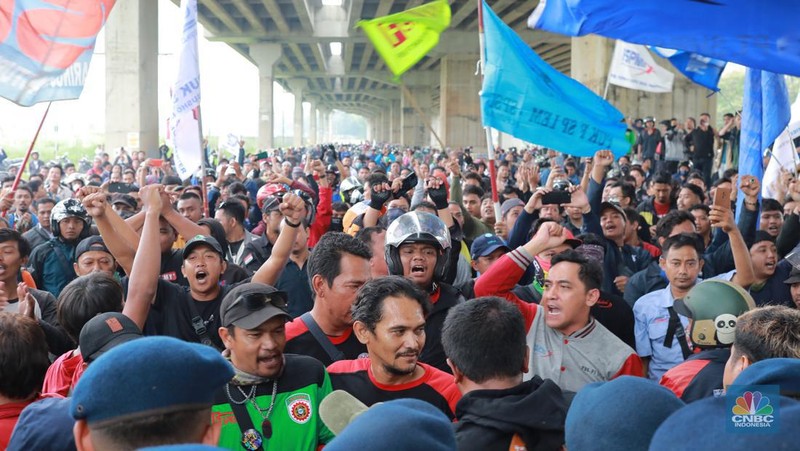Aliansi buruh Bekasi aksi dorong mendorong dengan petugas kepolisian di Kawasan Industri MM 2100, Kab Bekasi, Jawa Barat, Kamis, (30/11/2023). Buruh yang tergabung dalam Aliansi Buruh Bekasi Melawan (BBM) melakukan aksi unjuk rasa serentak di wilayah kabupaten dan kota Bekasi. (CNBC Indonesia/Muhammad Sabki)