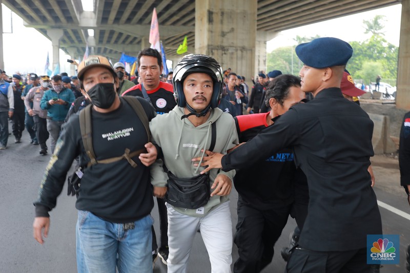 Aliansi buruh Bekasi aksi dorong mendorong dengan petugas kepolisian di Kawasan Industri MM 2100, Kab Bekasi, Jawa Barat, Kamis, (30/11/2023). Buruh yang tergabung dalam Aliansi Buruh Bekasi Melawan (BBM) melakukan aksi unjuk rasa serentak di wilayah kabupaten dan kota Bekasi. (CNBC Indonesia/Muhammad Sabki)