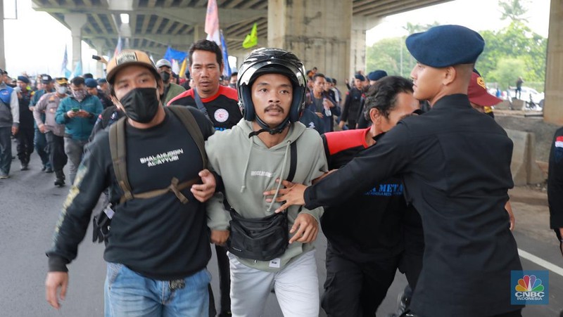Aliansi buruh Bekasi aksi dorong mendorong dengan petugas kepolisian di Kawasan Industri MM 2100, Kab Bekasi, Jawa Barat, Kamis, (30/11/2023). Buruh yang tergabung dalam Aliansi Buruh Bekasi Melawan (BBM) melakukan aksi unjuk rasa serentak di wilayah kabupaten dan kota Bekasi. (CNBC Indonesia/Muhammad Sabki)