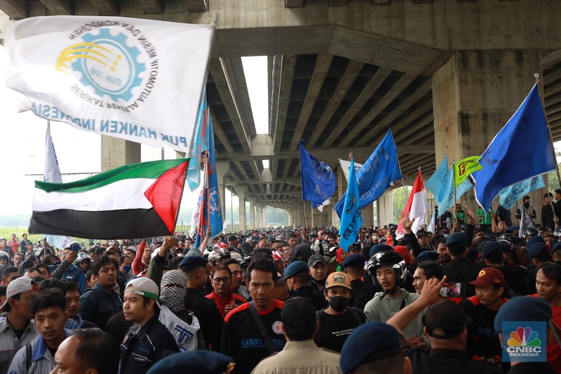 Aliansi buruh Bekasi aksi dorong mendorong dengan petugas kepolisian di Kawasan Industri MM 2100, Kab Bekasi, Jawa Barat, Kamis, (30/11/2023). Buruh yang tergabung dalam Aliansi Buruh Bekasi Melawan (BBM) melakukan aksi unjuk rasa serentak di wilayah kabupaten dan kota Bekasi. (CNBC Indonesia/Muhammad Sabki)