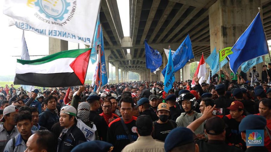 Aliansi buruh Bekasi aksi dorong mendorong dengan petugas kepolisian di Kawasan Industri MM 2100, Kab Bekasi, Jawa Barat, Kamis, (30/11/2023). Buruh yang tergabung dalam Aliansi Buruh Bekasi Melawan (BBM) melakukan aksi unjuk rasa serentak di wilayah kabupaten dan kota Bekasi. (CNBC Indonesia/Muhammad Sabki)