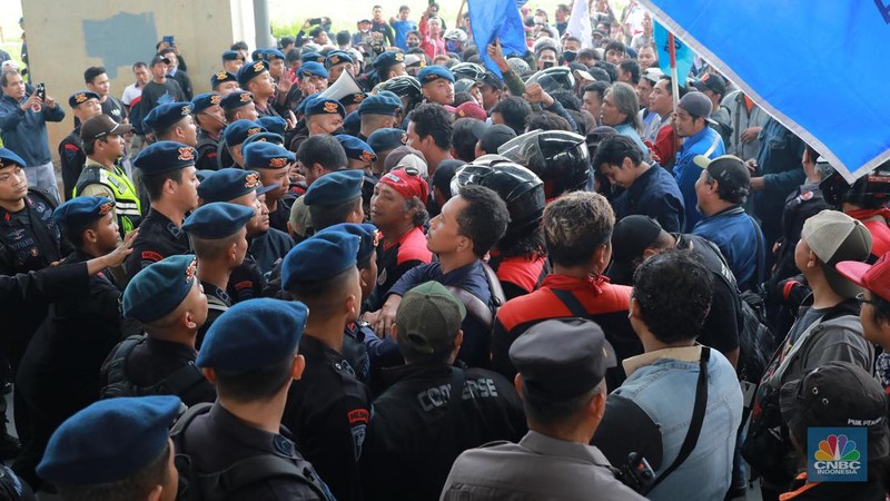 Aliansi buruh Bekasi aksi dorong mendorong dengan petugas kepolisian di Kawasan Industri MM 2100, Kab Bekasi, Jawa Barat, Kamis, (30/11/2023). Buruh yang tergabung dalam Aliansi Buruh Bekasi Melawan (BBM) melakukan aksi unjuk rasa serentak di wilayah kabupaten dan kota Bekasi. (CNBC Indonesia/Muhammad Sabki)