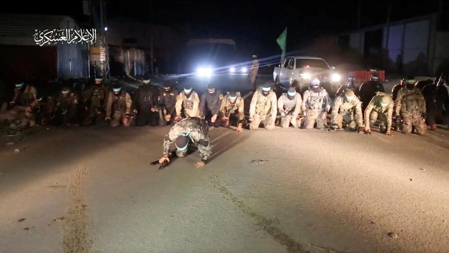 Pasukan Hamas melakukan sujud syukur setelah melepaskan para sandera Israel di tengah gencatan senjata sementara, di lokasi yang tidak diketahui di Jalur Gaza. (via REUTERS/AL-QASSAM BRIGADES, MILITARY WIN)