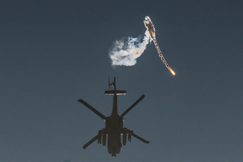 ISRAEL-PALESTINIANS/GAZA-ROCKETS An Israeli military helicopter releases a flare over the Israel-Gaza border, after a temporary truce between Israel and the Palestinian Islamist group Hamas expired, as seen from southern Israel, December 1, 2023. REUTERS/Amir Cohen TPX IMAGES OF THE DAY