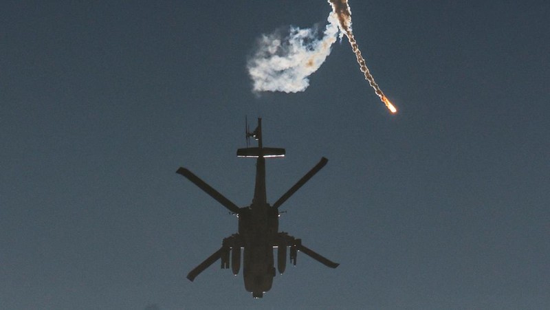 An Israeli military helicopter releases a flare over the Israel-Gaza border, after a temporary truce between Israel and the Palestinian Islamist group Hamas expired, as seen from southern Israel, December 1, 2023. REUTERS/Amir Cohen     TPX IMAGES OF THE DAY