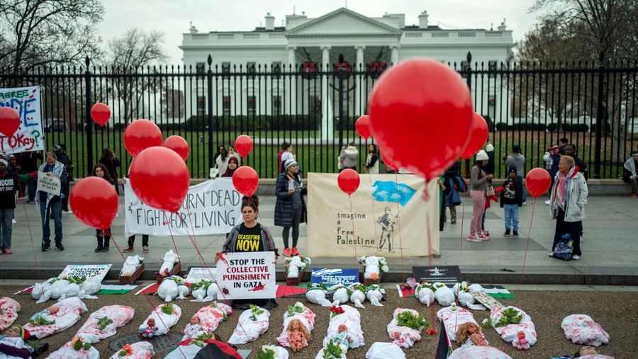 Demonstran pro-Palestina yang mengenakan kain putih tergeletak di tanah di luar Gedung Putih di Washington, AS, 2 Desember 2023. Orang-orang berkumpul dalam solidaritas setelah gencatan senjata sementara antara Israel dan Hamas berakhir awal pekan ini. (REUTERS/Bonnie Cash)