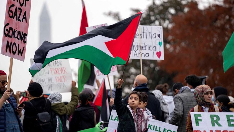 Seorang anak laki-laki mengibarkan bendera Palestina saat demonstrasi pro-Palestina di Lafayette Square dekat Gedung Putih di Washington, AS, 2 Desember 2023. Orang-orang berkumpul dalam solidaritas setelah gencatan senjata sementara berakhir antara Israel dan Hamas awal pekan ini. (REUTERS/Bonnie Cash)