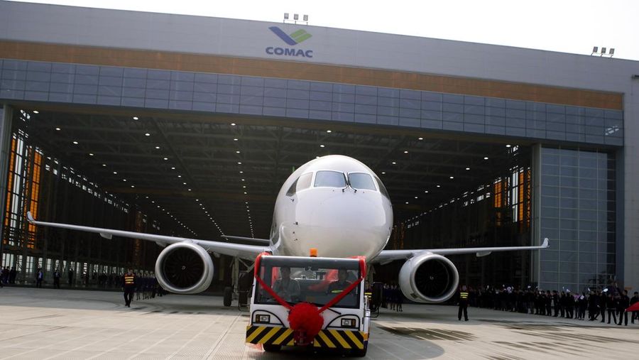 Pekerja Tiongkok mengibarkan bendera ketika sebuah truk mengeluarkan pesawat penumpang C919 bermesin ganda yang dibuat oleh The Commercial Aircraft Corp. of China (COMAC) di Shanghai, Tiongkok, Senin , 2 November 2015. (AP Photo/File Foto)