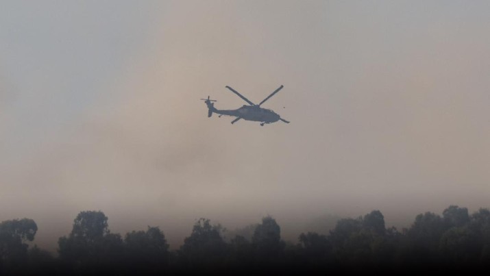 Sebuah helikopter terbang di dekat perbatasan dengan Gaza, di tengah konflik yang sedang berlangsung antara Israel dan kelompok Islam Palestina Hamas, terlihat dari Israel selatan, 4 Desember 2023. (REUTERS/Athit Perawongmetha)