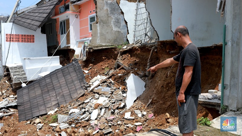Sejumlah warga melihat kondisi rumah yang longsor di Kawasan Desa Kuripan, Kecamatan Ciseeng, Kabupaten Bogor, Jawa Barat, Selasa, (5/12/2023). (CNBC Indonesia/Muhammad Sabki)