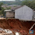 Sejumlah warga melihat kondisi rumah yang longsor di Kawasan Desa Kuripan, Kecamatan Ciseeng, Kabupaten Bogor, Jawa Barat, Selasa, (5/12/2023). (CNBC Indonesia/Muhammad Sabki)