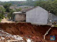Sejumlah warga melihat kondisi rumah yang longsor di Kawasan Desa Kuripan, Kecamatan Ciseeng, Kabupaten Bogor, Jawa Barat, Selasa, (5/12/2023). (CNBC Indonesia/Muhammad Sabki)