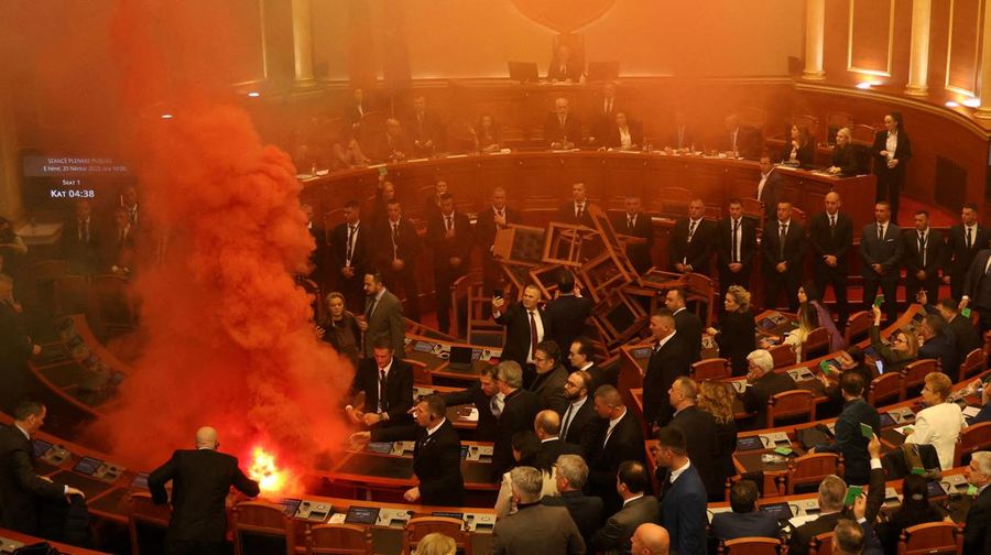 Seorang anggota parlemen dari Partai Demokrat, yang merupakan partaimoposisi terbesar Albania menyalakan bom asap berwarna sebagai tanda protes saat sidang parlemen di Tirana, Albania, Senin (4/12/2023). (REUTERS/Florion Goga)