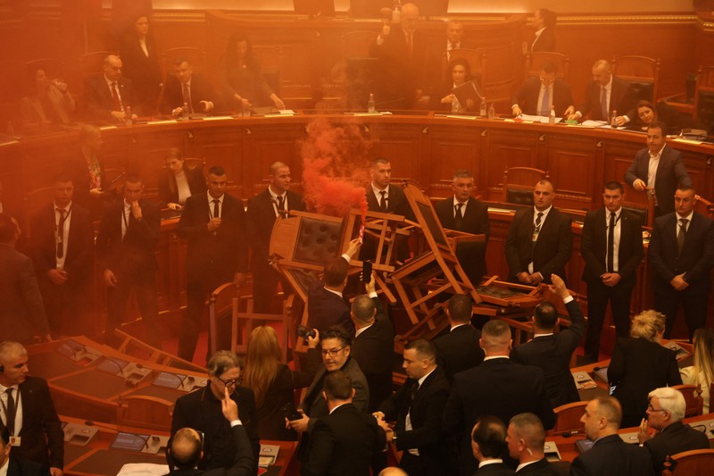 Seorang anggota parlemen dari Partai Demokrat, yang merupakan partaimoposisi terbesar Albania menyalakan bom asap berwarna sebagai tanda protes saat sidang parlemen di Tirana, Albania, Senin (4/12/2023). (REUTERS/Florion Goga) Seorang anggota parlemen dari Partai Demokrat, yang merupakan partaimoposisi terbesar Albania menyalakan bom asap berwarna sebagai tanda protes saat sidang parlemen di Tirana, Albania, Senin (4/12/2023). (REUTERS/Florion Goga)
