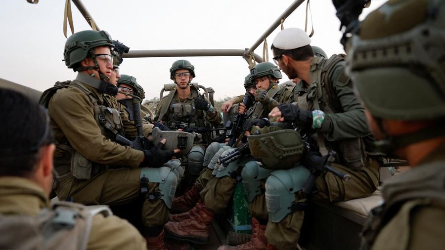 Tentara Israel duduk di dalam kendaraan militer, di tengah konflik yang sedang berlangsung antara Israel dan kelompok Islam Palestina Hamas, dekat perbatasan Israel dengan Gaza, di Israel selatan, 4 Desember 2023. (REUTERS/Amir Cohen)