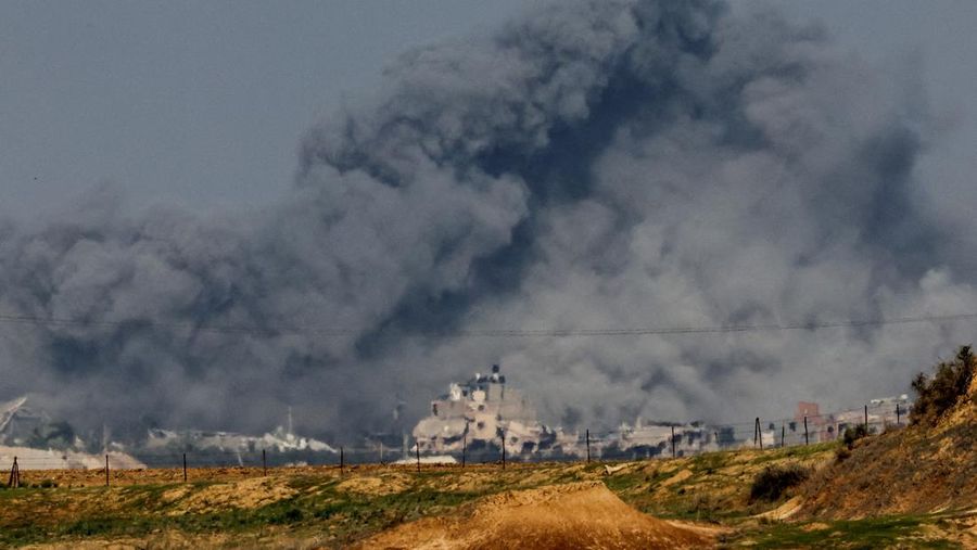 Asap mengepul di antara bangunan-bangunan yang hancur akibat serangan Israel, di tengah konflik yang sedang berlangsung antara Israel dan kelompok Islam Palestina Hamas, di perbatasan Israel-Gaza dilihat dari Israel selatan, 6 Desember 2023. (REUTERS/Athit Perawongmetha)
