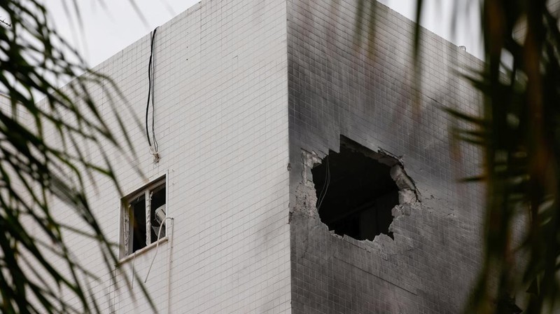Kondisi bangunan apartemen yang berlubang akibat serangan roket yang diduga milik kelompok militan Hamas di Ashkelon, Israel, Selasa (5/12/2023). (REUTERS/Amir Cohen)