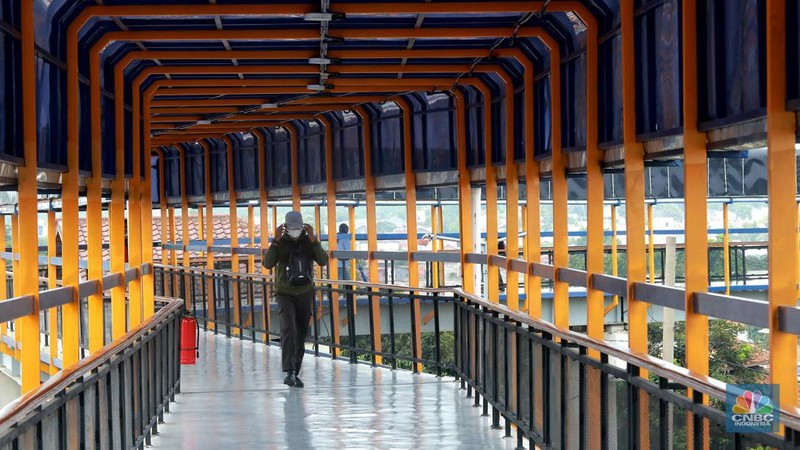 Warga berjalan di area Skybridge Bojonggede di Kabupaten Bogor, Jawa Barat, Rabu, (6/12/2023). Skybridge ini mulai dibuka untuk uji coba 6-7 Desember 2023. Skybridge ini menghubungkan terminal dengan Stasiun Bojonggede. (CNBC Indonesia/Muhammad Sabki)