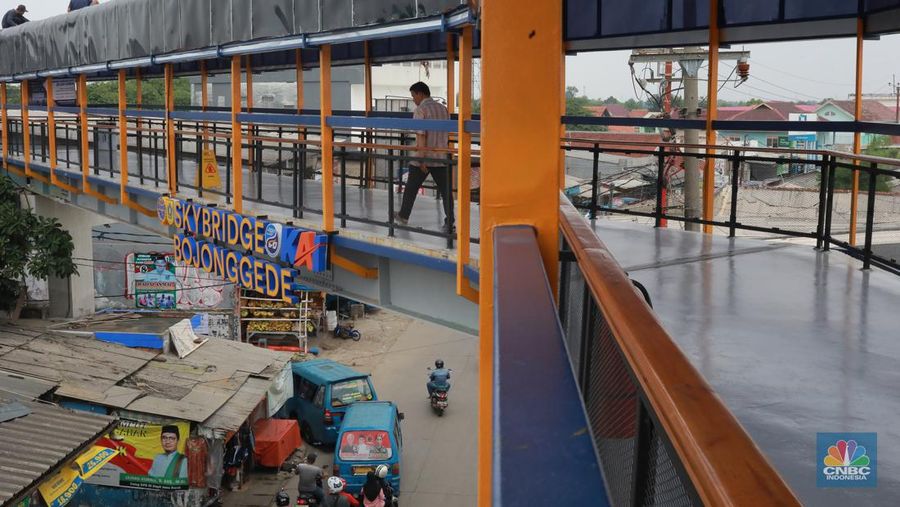 Warga berjalan di area Skybridge Bojonggede di Kabupaten Bogor, Jawa Barat, Rabu, (6/12/2023). Skybridge ini mulai dibuka untuk uji coba 6-7 Desember 2023. Skybridge ini menghubungkan terminal dengan Stasiun Bojonggede. (CNBC Indonesia/Muhammad Sabki)